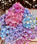 An artistic flower board showcasing a blend of blue hydrangeas and soft pink roses.