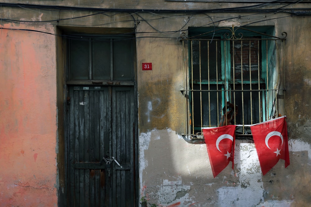 two turkish flags hanging outside of a window
