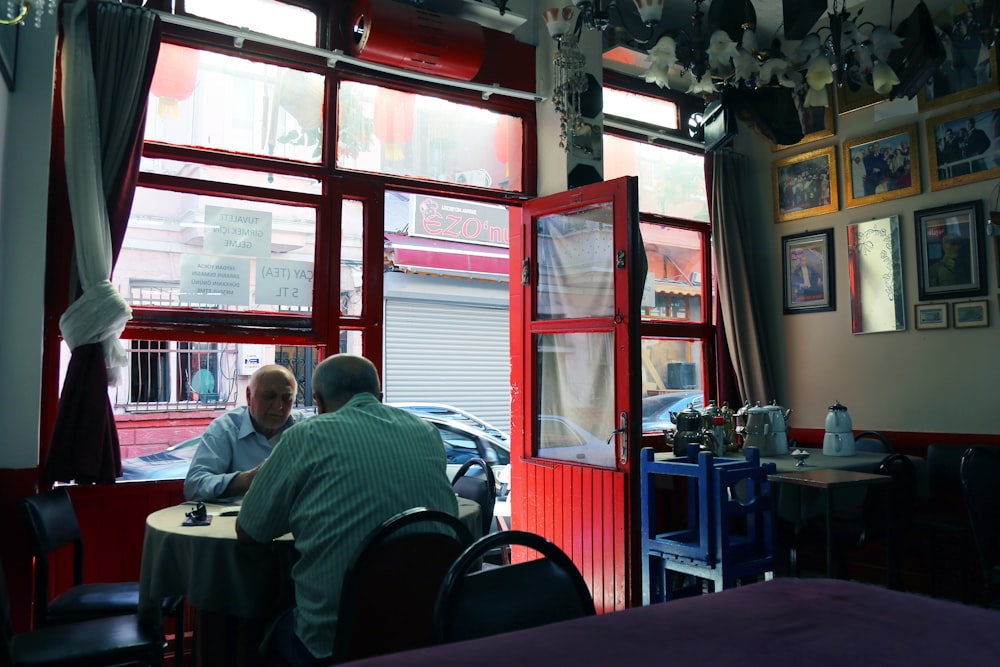 a couple of men sitting at a table in a restaurant