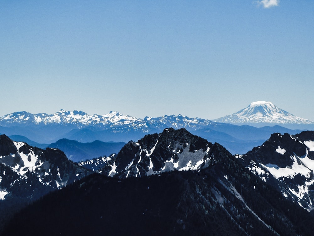 a mountain range with snow capped mountains in the background