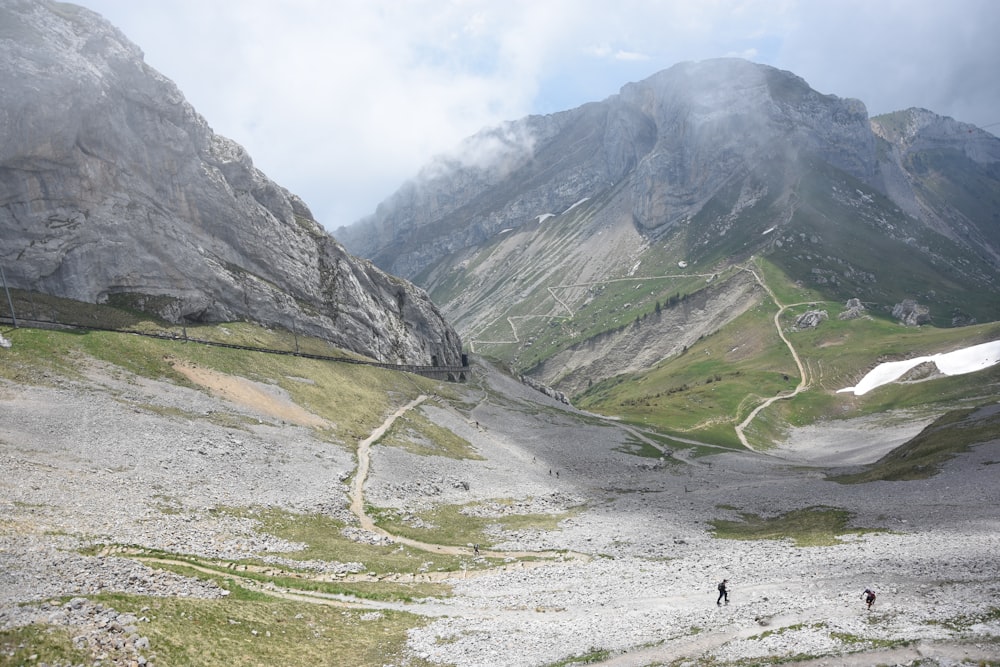 a couple of people walking up a mountain side