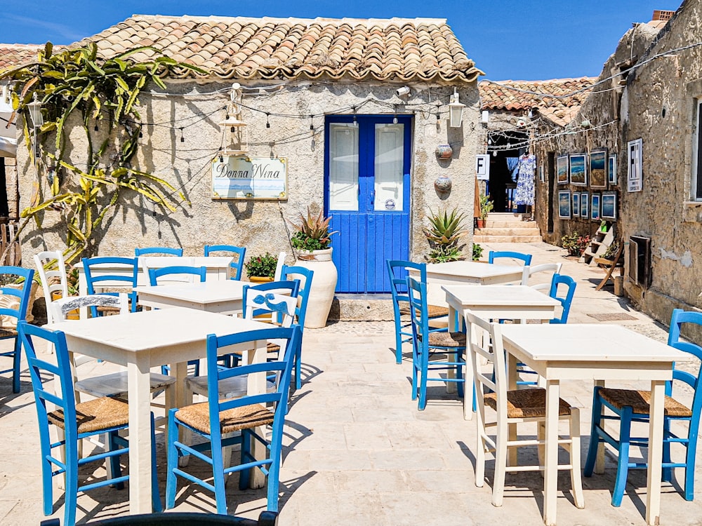tavoli e sedie all'esterno di un ristorante con una porta blu