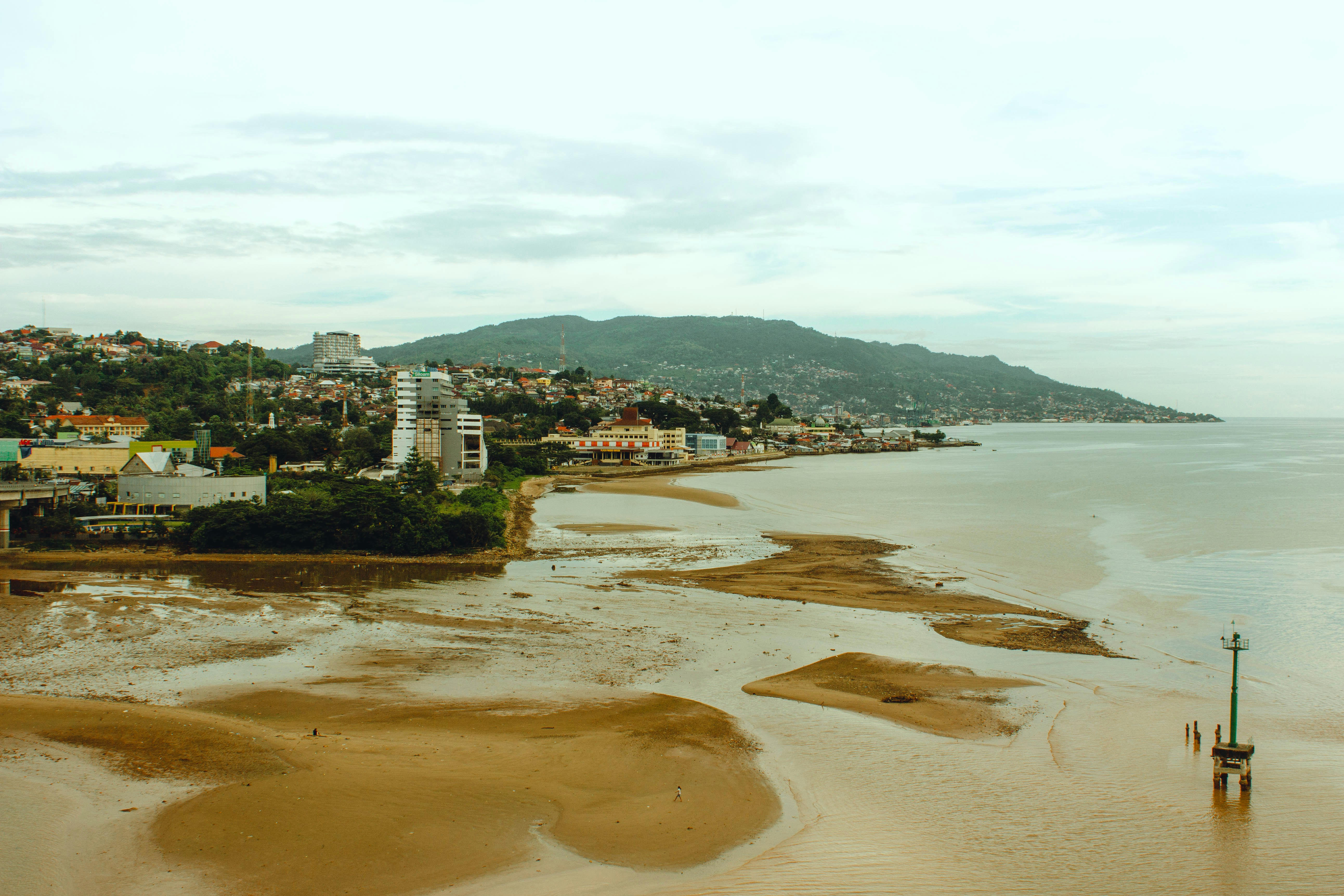 an aerial view of a beach with a city in the background, A view of Ambon Bay