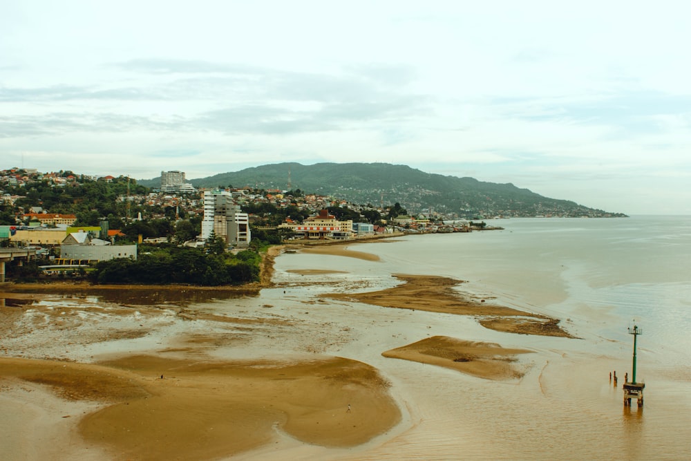 an aerial view of a beach with a city in the background