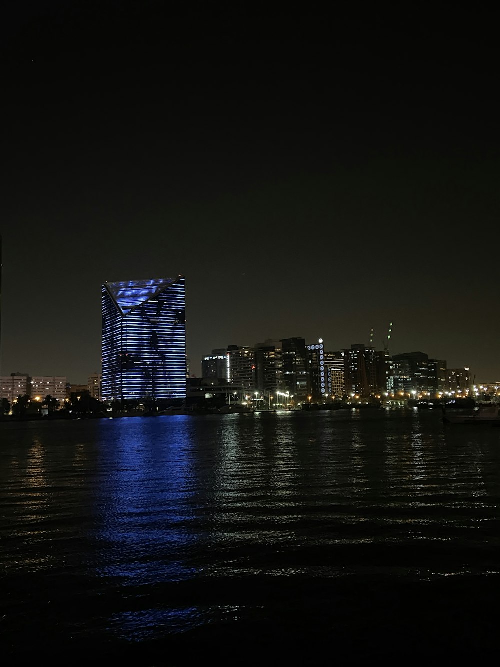 a night view of a city with lights reflecting off the water