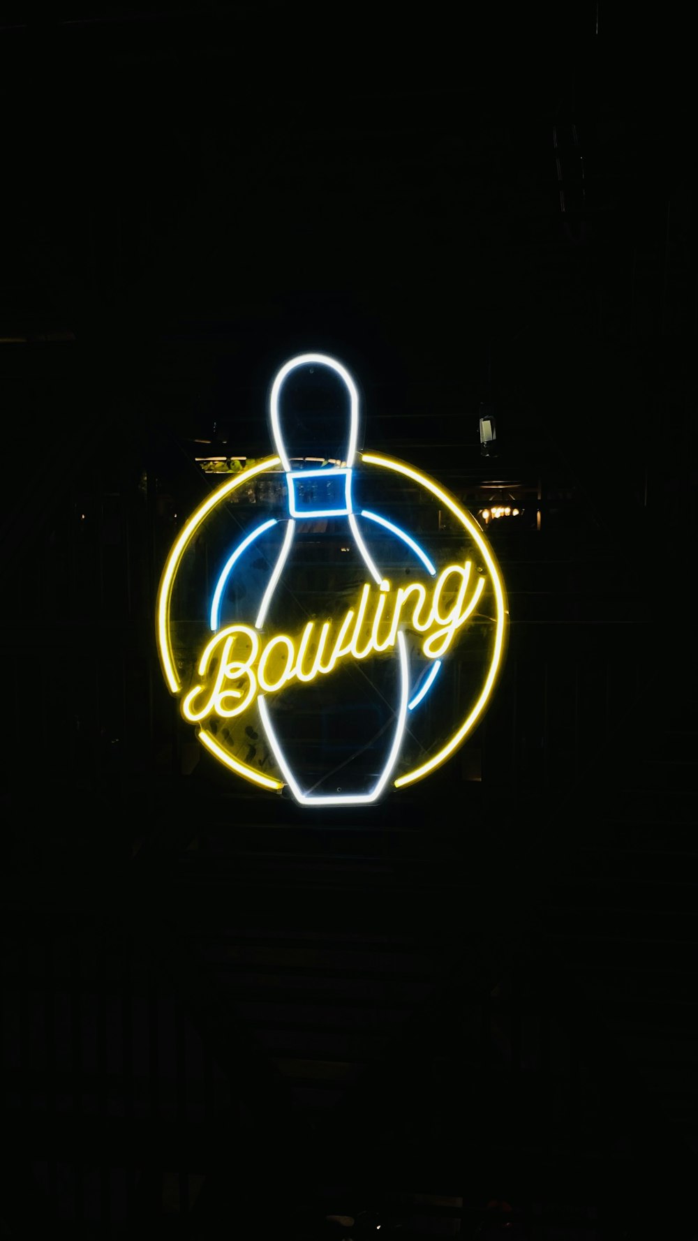 a neon bowling sign lit up in the dark