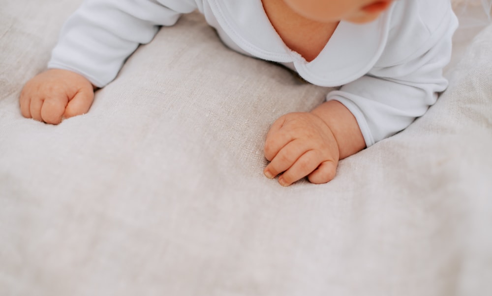 a baby laying on its back on a bed