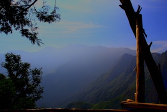 A serene landscape with mountains in the background and a clear blue sky.