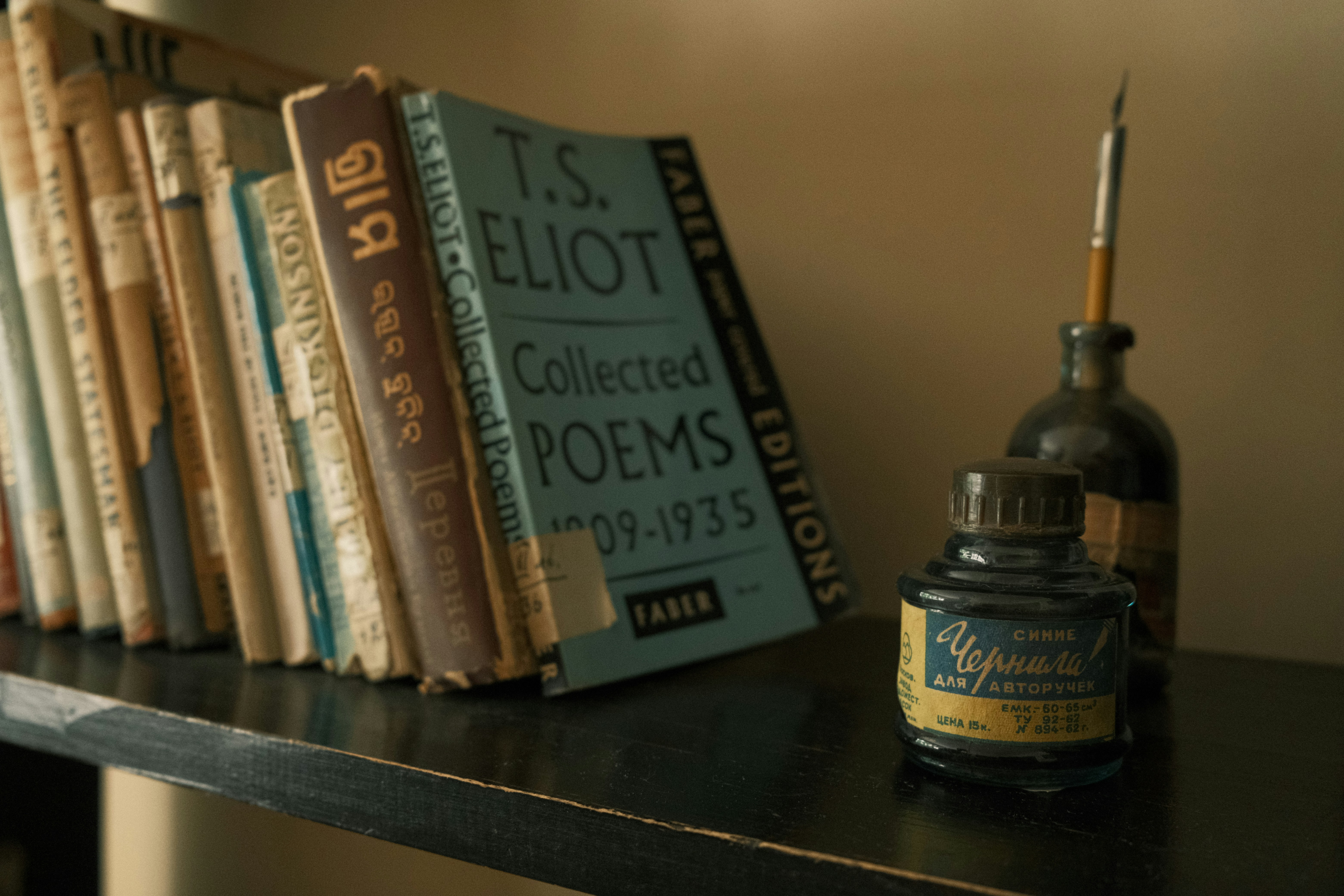 a shelf with books and a bottle of ink