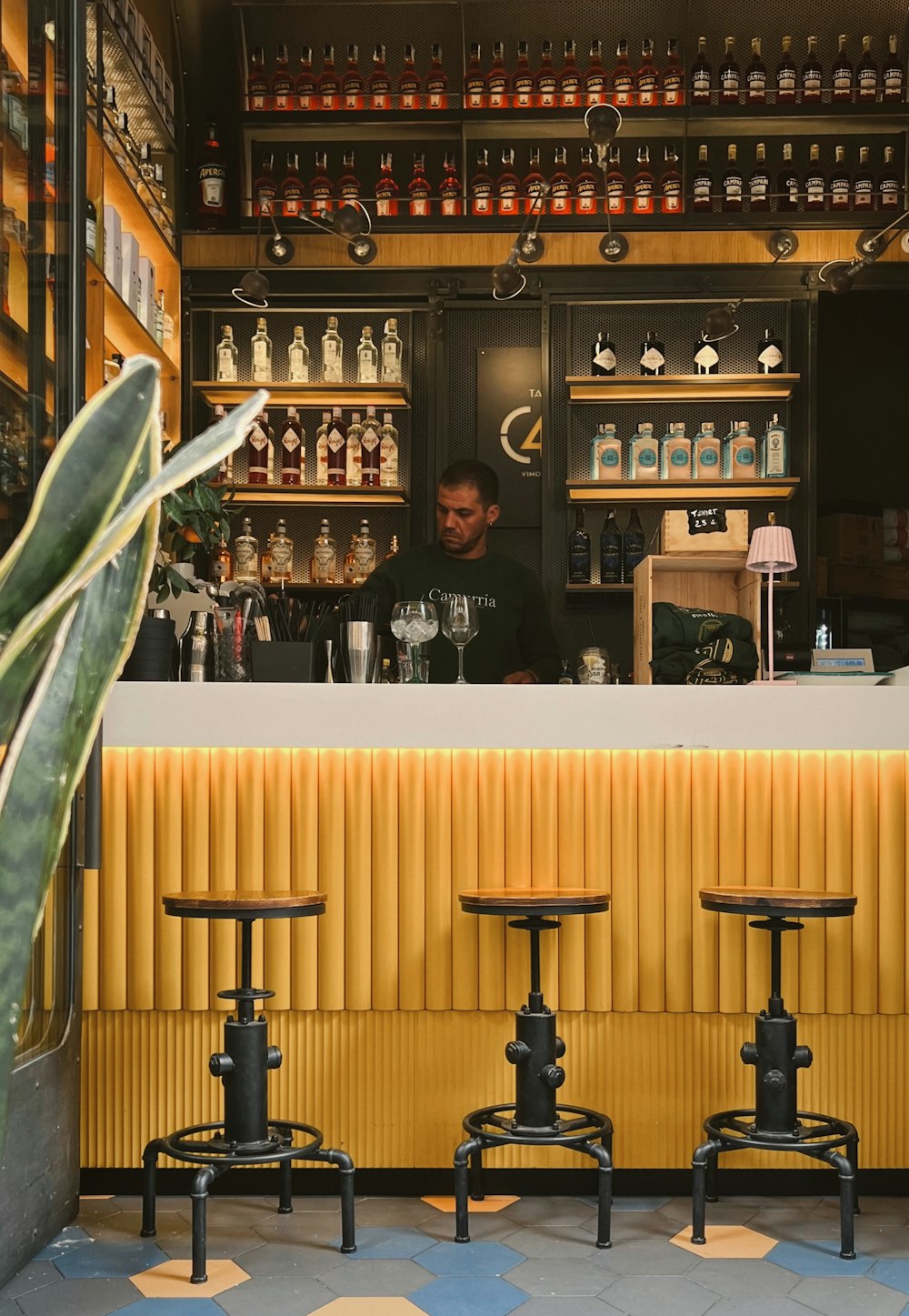 a man sitting at a bar behind three stools