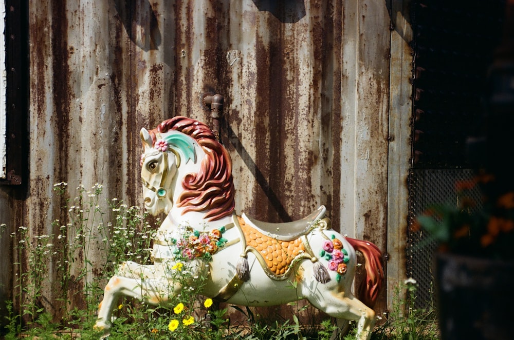 a statue of a horse in a field of flowers