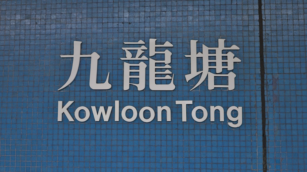a sign that says kowloon tongg on the side of a building