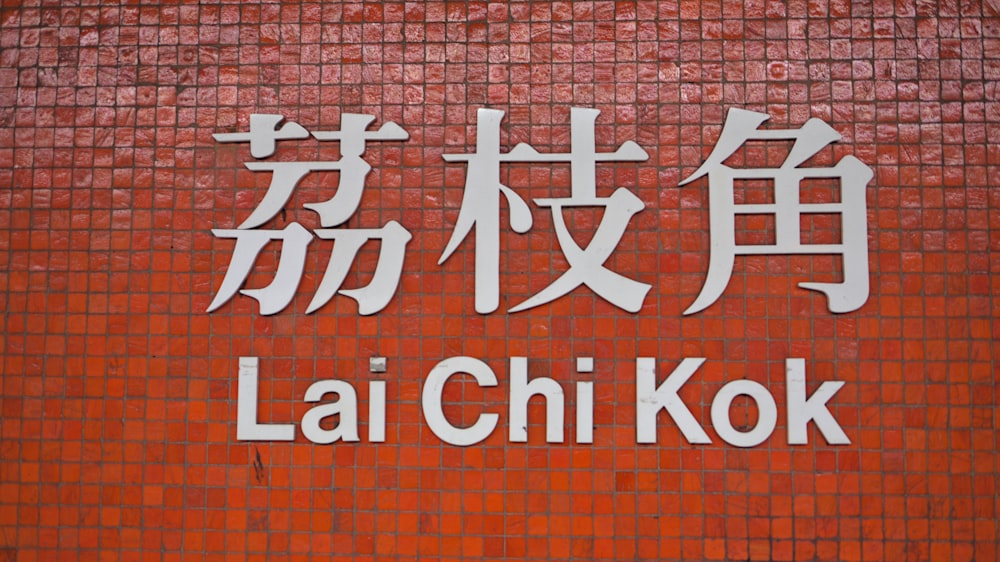 a sign on a brick wall that says lai chi kok