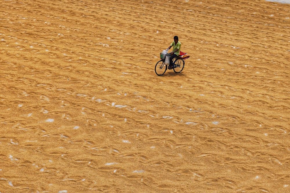 a person riding a bike on a sandy beach