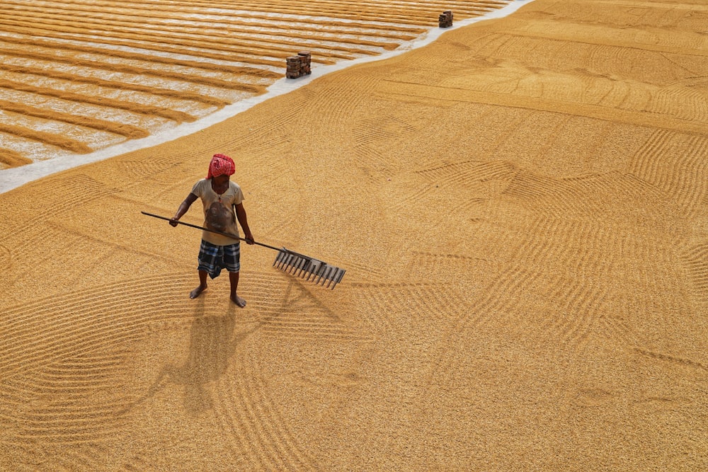 a man with a shovel and rake in a field