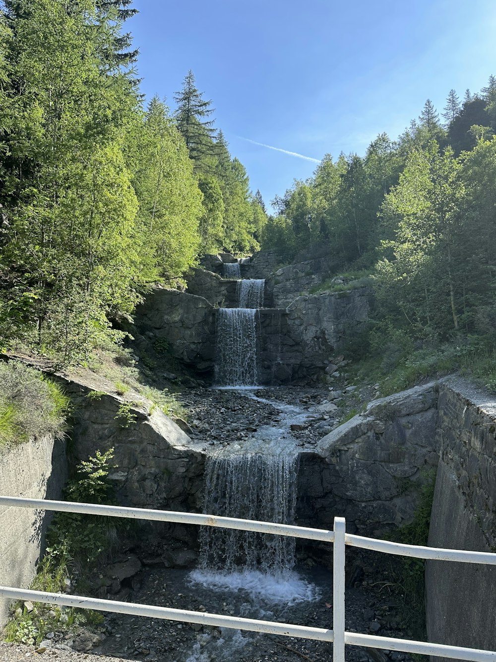 a small waterfall in the middle of a forest