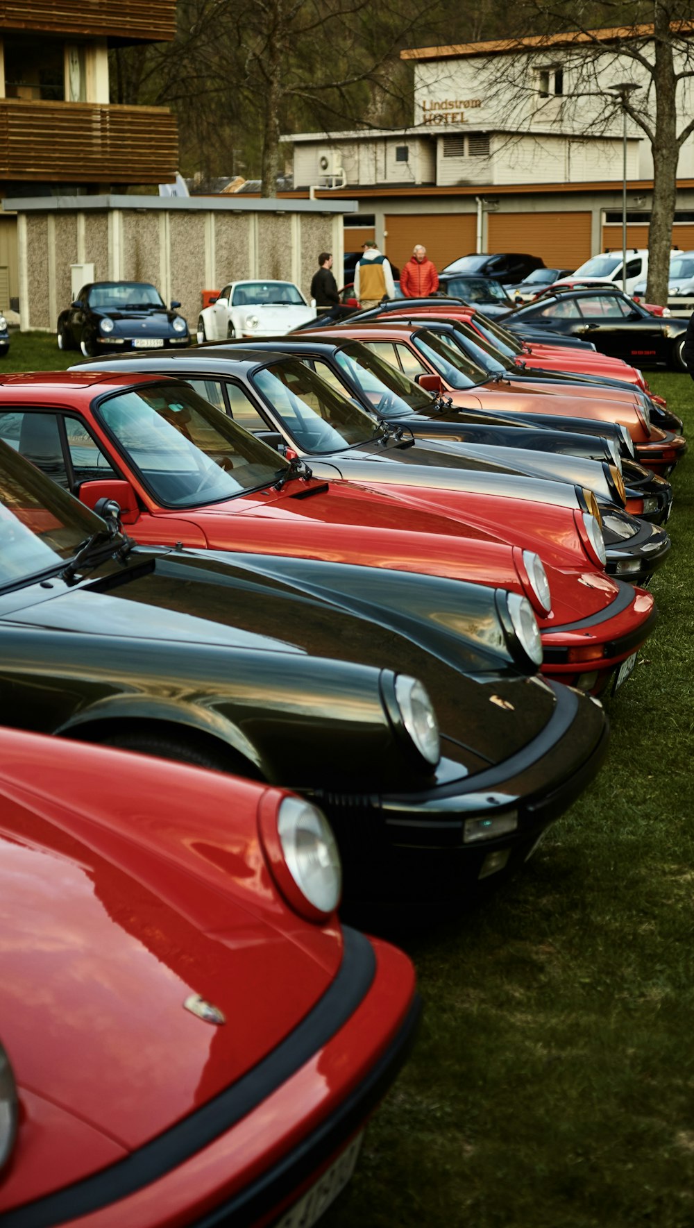 eine Reihe geparkter Autos, die auf einer üppigen grünen Wiese sitzen