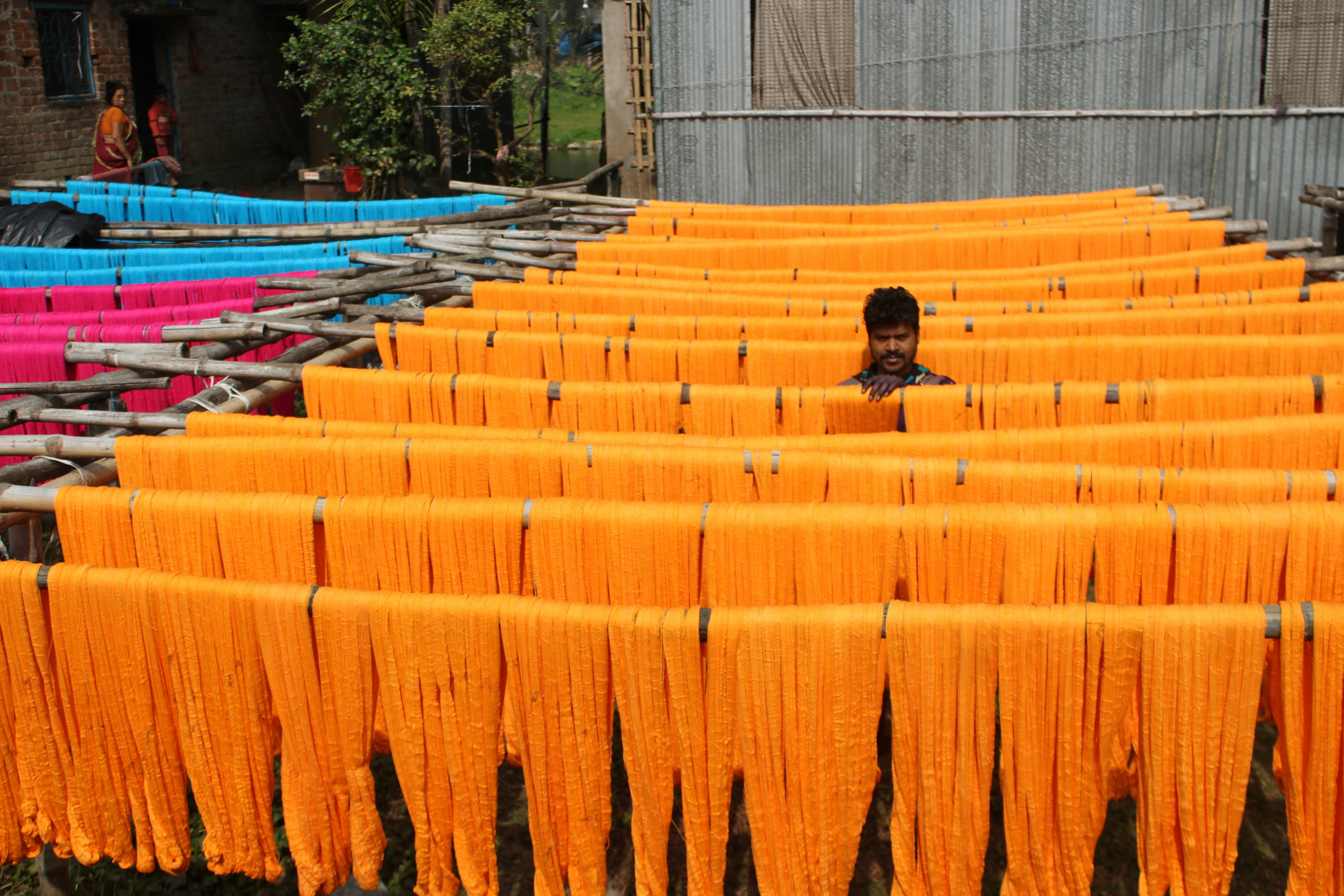 a woman standing in front of a row of orange cloths
