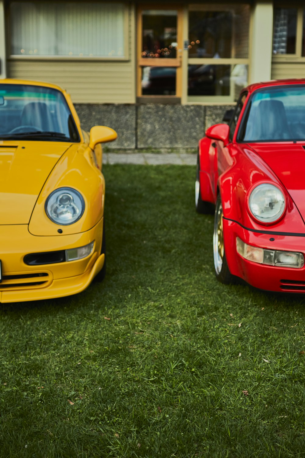 ein paar Autos, die auf einer üppigen grünen Wiese geparkt sind