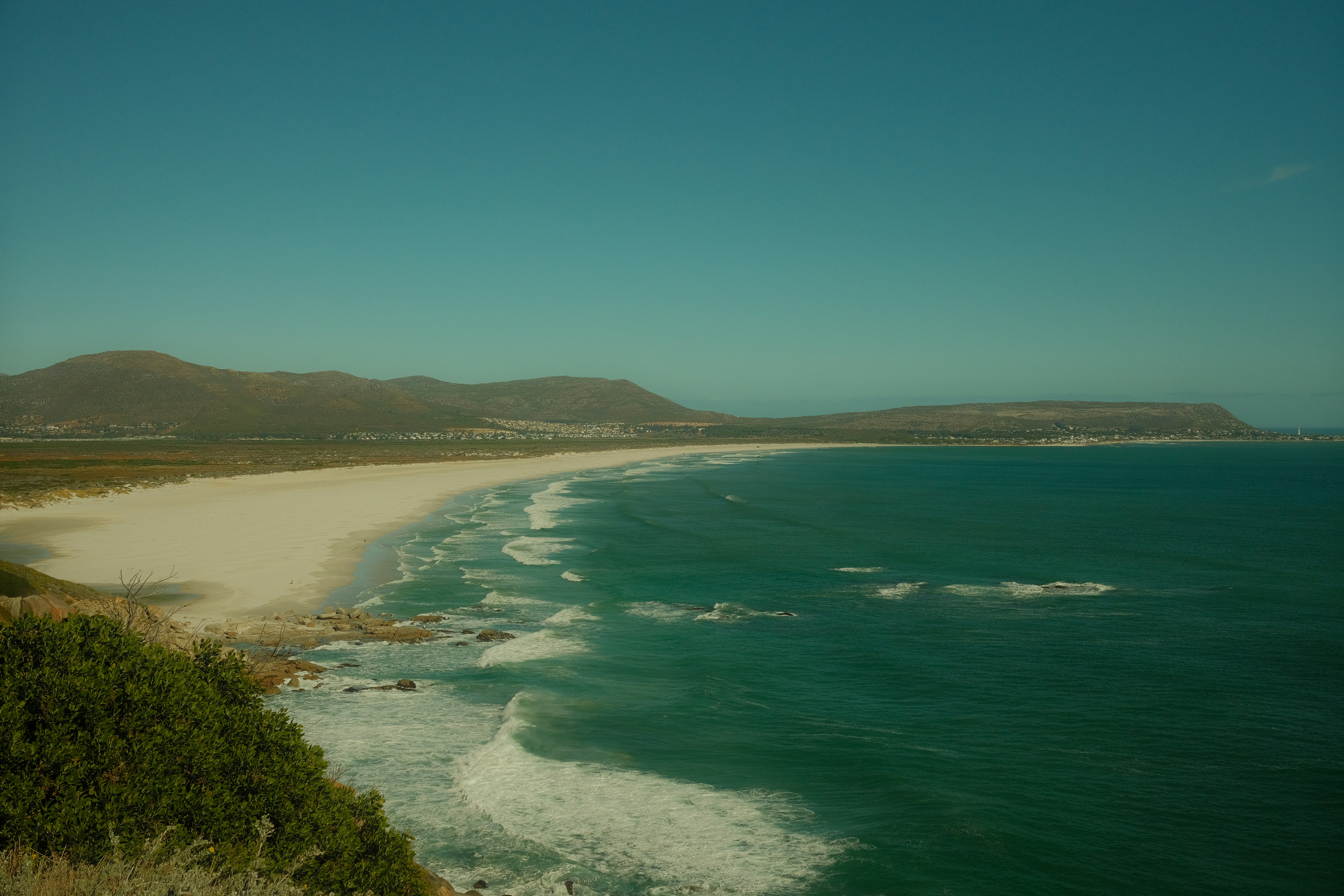 a view of a beach from the top of a hill