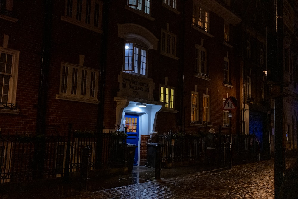 a dark city street at night with a blue door