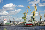 A cargo ship docked at a busy port with cranes unloading goods efficiently.
