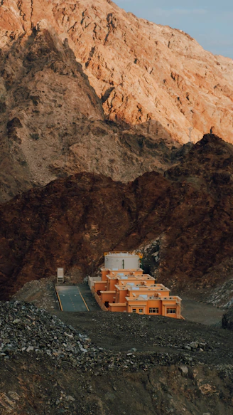 a mountain side with a building in the foreground