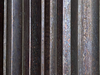 Close-up of corten steel facade lamella with rich rust texture and sharp edges.