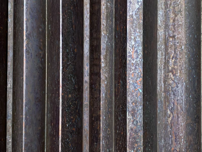 Close-up of corten steel facade lamella with rich rust texture and sharp edges.