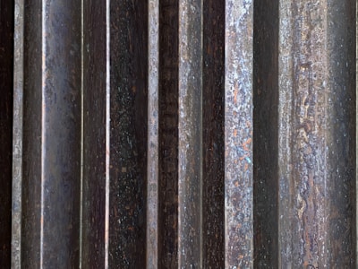 Close-up of a sleek metal panel with a deep black oxidation finish highlighting fine grain texture.