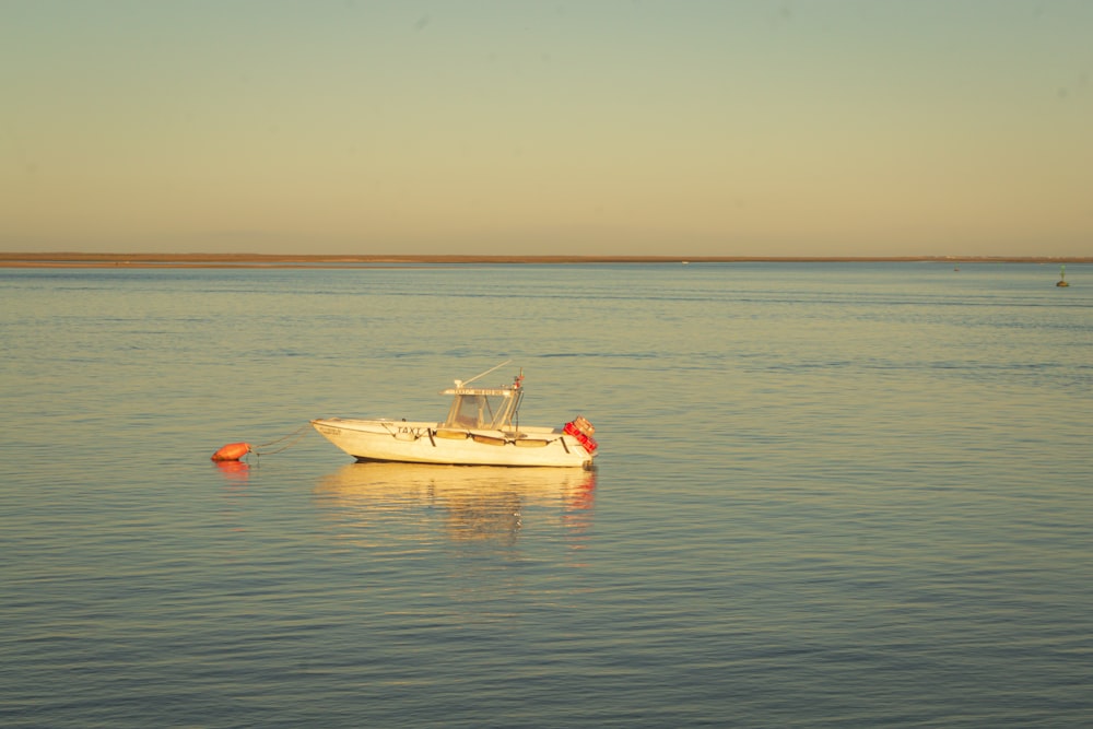 a small boat floating on top of a large body of water