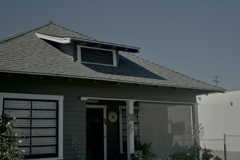 a house with a gray roof and a white fence