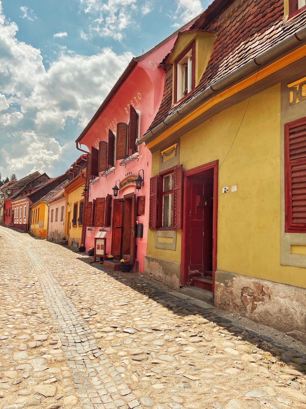 a cobblestone street lined with brightly colored buildings