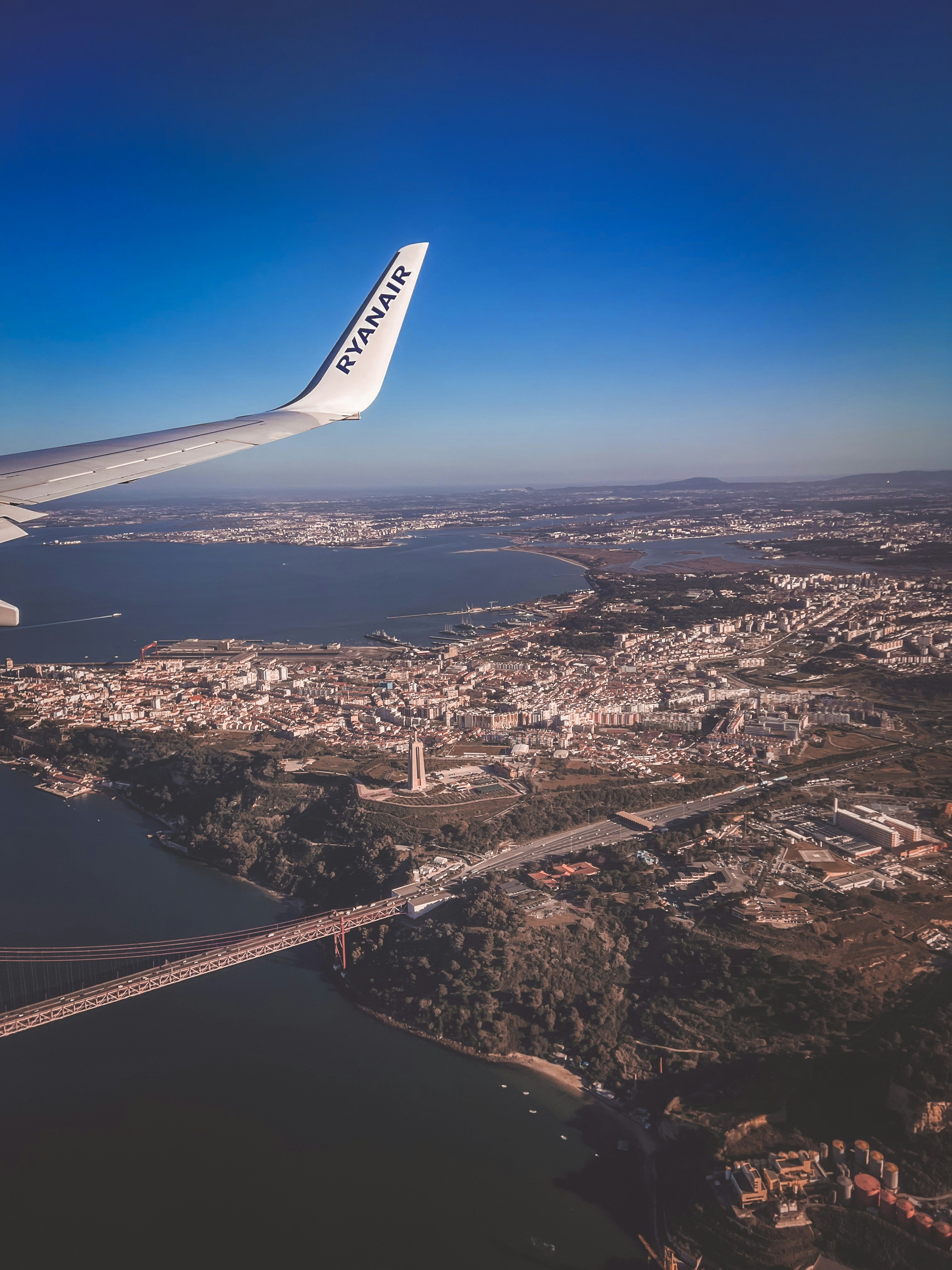the wing of an airplane flying over a city