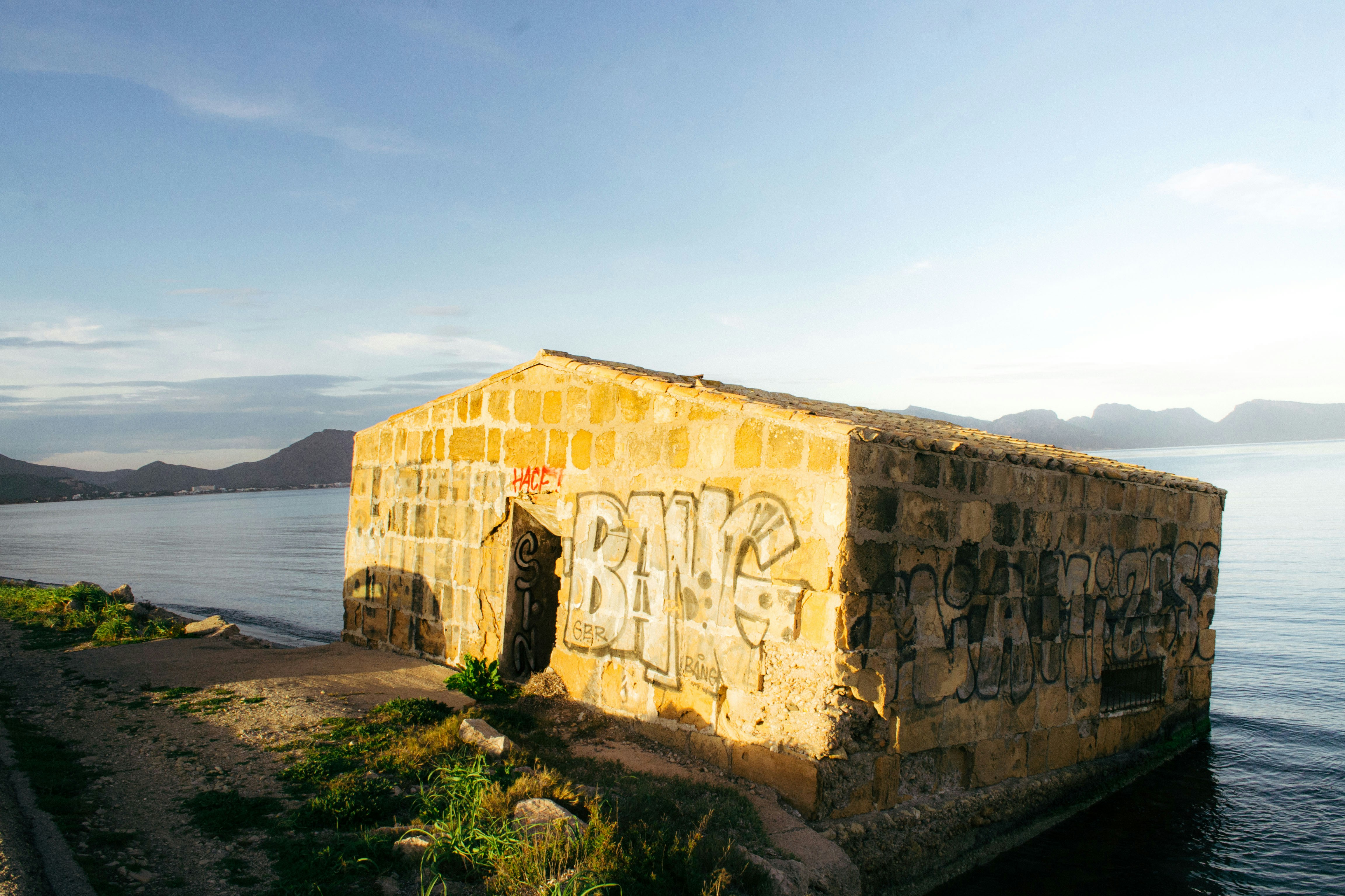 a building with graffiti on the side of the water