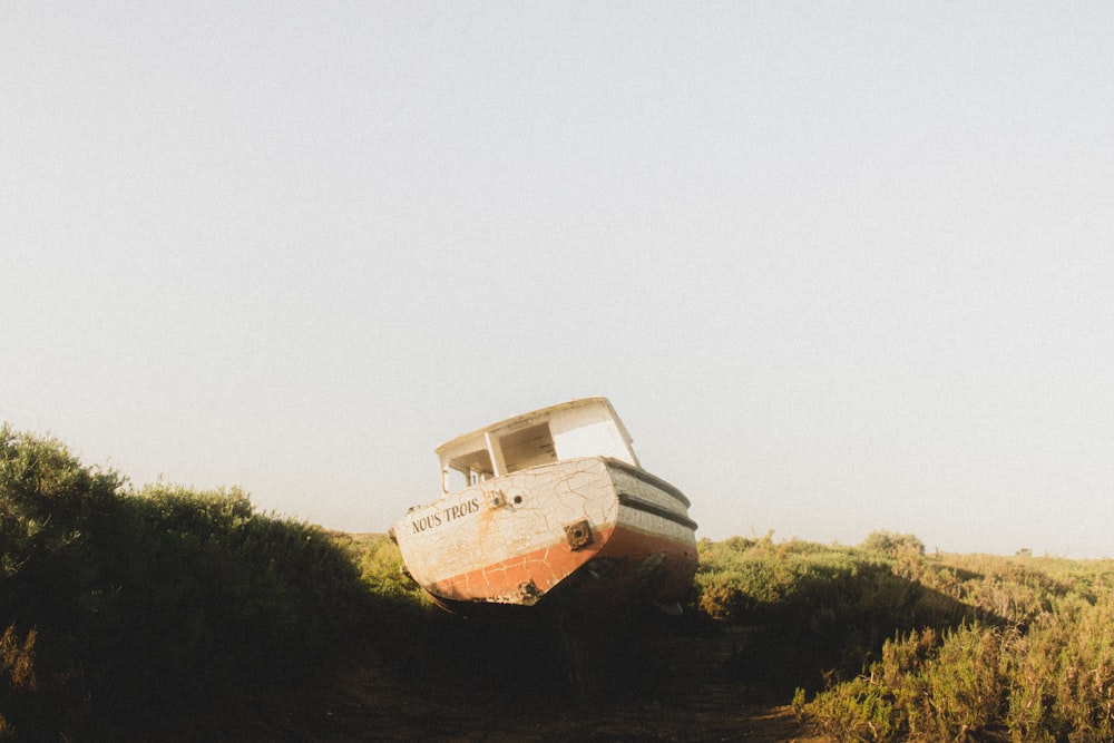 a boat sitting on top of a lush green field