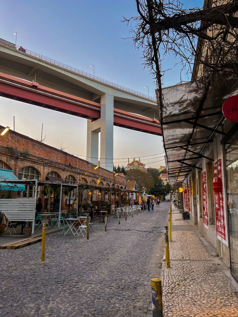 a street lined with shops under a bridge