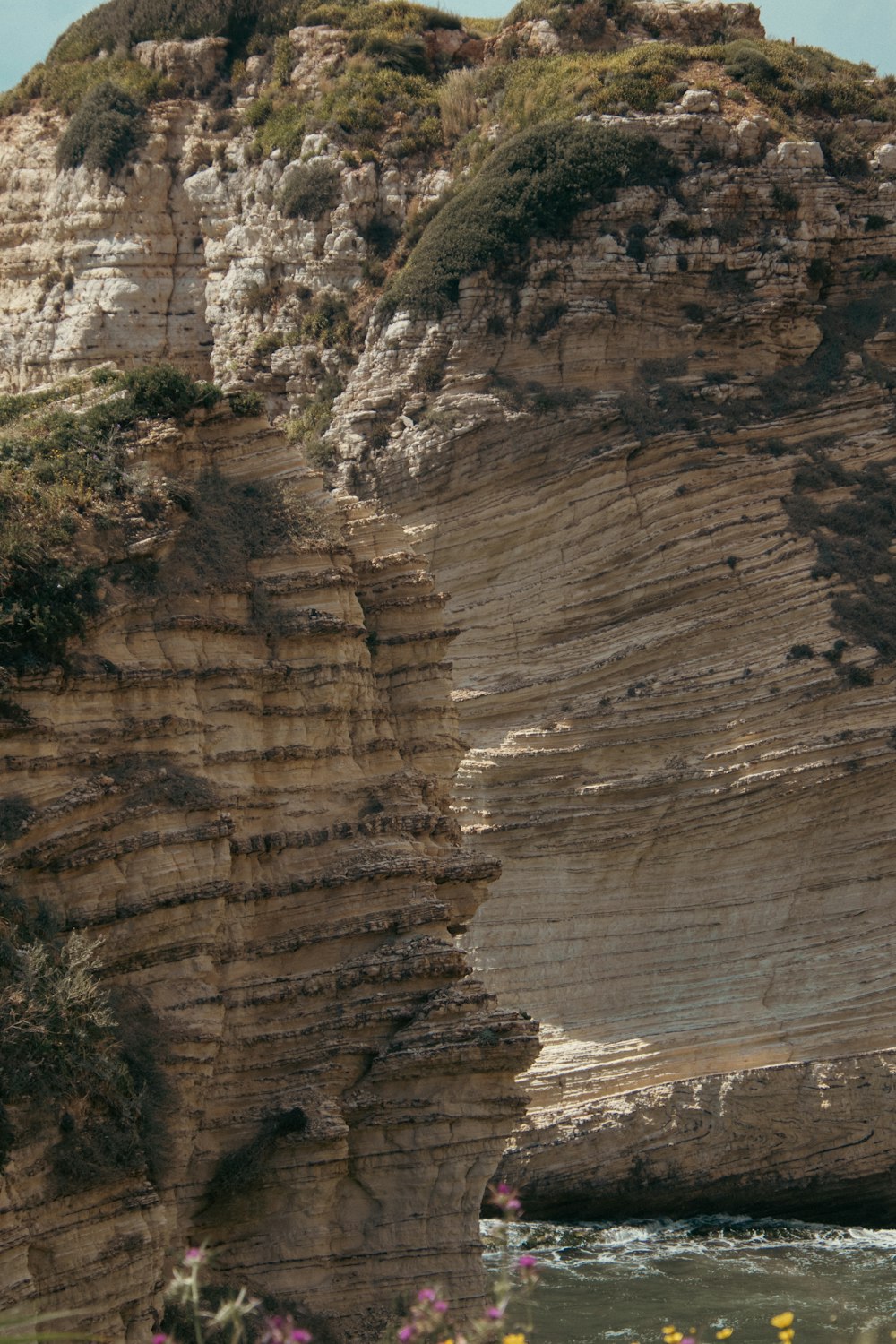 a large rock formation with a body of water in front of it