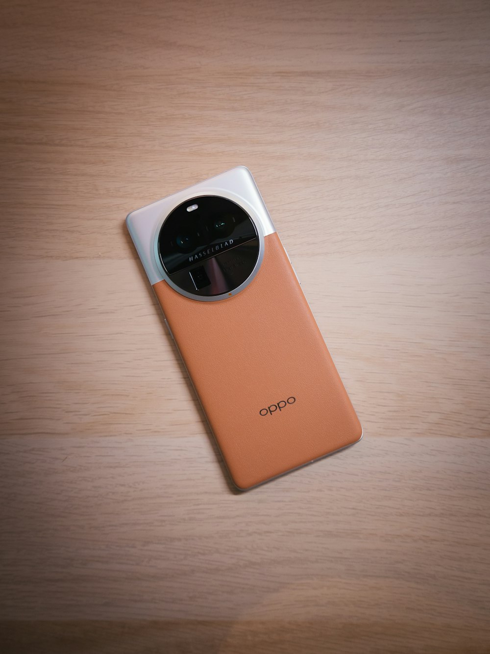 an orange cell phone sitting on top of a wooden table