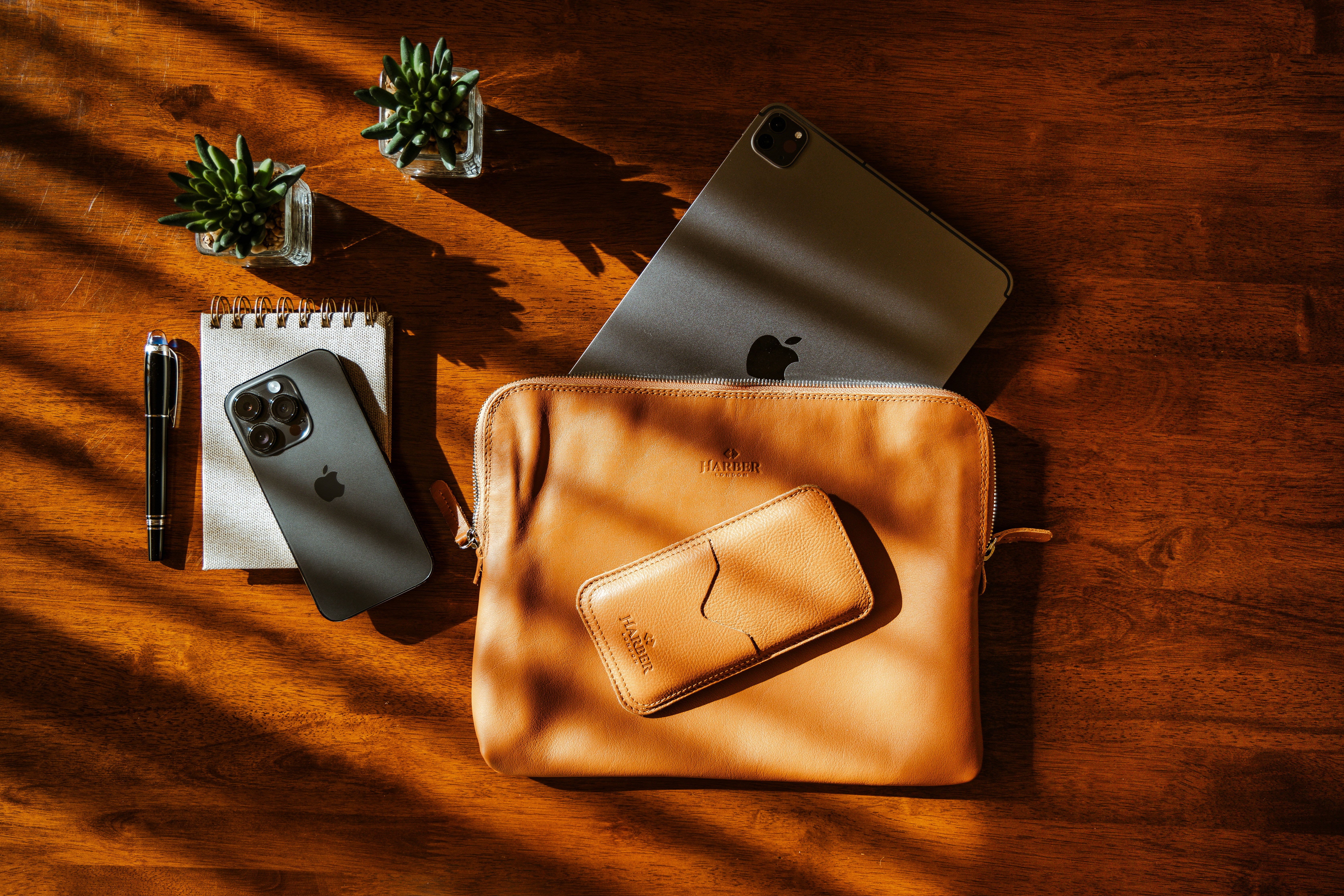 a wooden table topped with a laptop computer