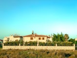 Close-up of a villa’s stone facade with lush greenery surrounding it.