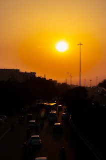 Sunset over a bustling Los Angeles highway with trucks in motion.