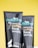 Two black tubes with colorful text display skincare products on a bright yellow background. Each tube features branding details and product descriptions like 'coffee face wash' and 'coffee face scrub'. A small graphic of a wolf at the bottom adds a distinct design element.