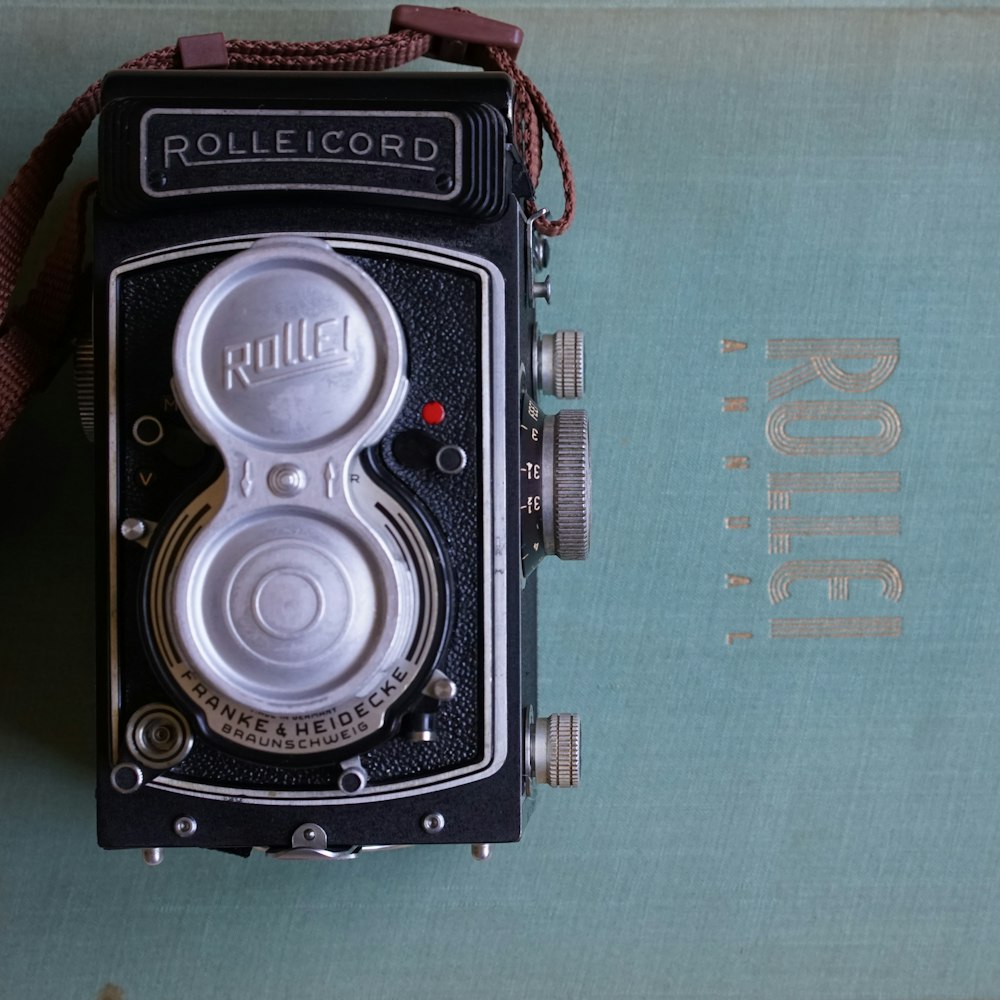 an old camera sitting on top of a book