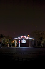 Technician carefully dismantling a shopping mall kiosk in São Paulo at night