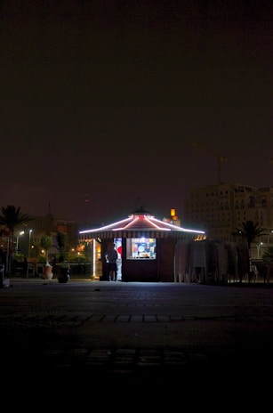 Team working at night to assemble a kiosk inside a brightly lit shopping center.