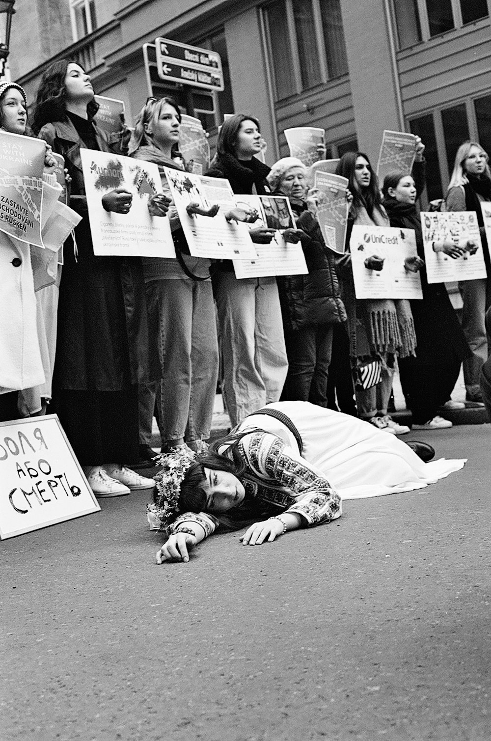 a group of people holding signs and laying on the ground