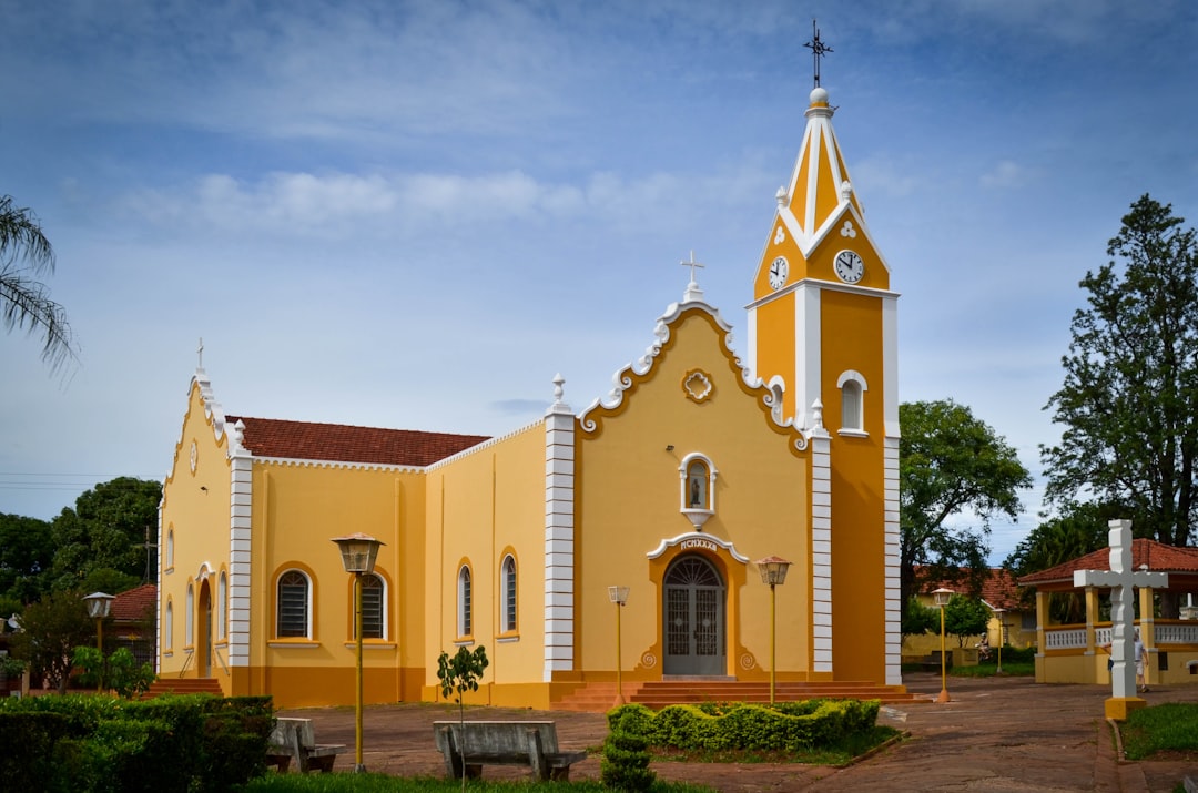 a yellow and white church with a clock tower, Old yellow church in a small size town