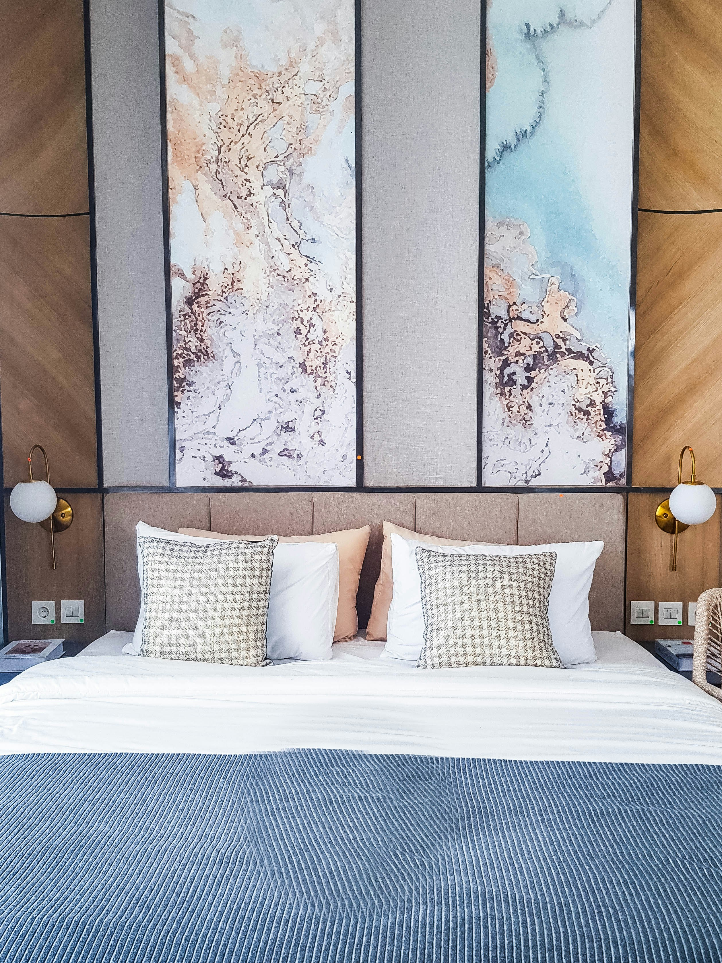 a bed with a blue and white comforter and pillows