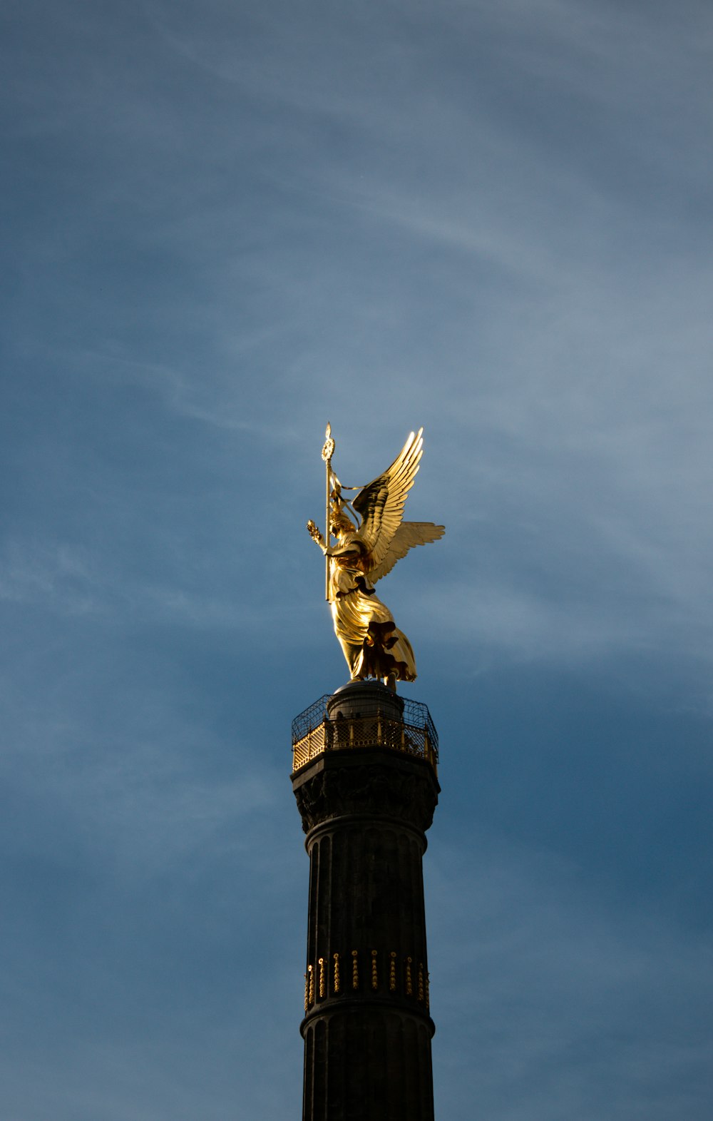Una estatua dorada en la cima de una torre alta